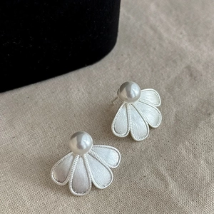 Elegant brushed silver petal stud earrings with white pearls in a minimalist design