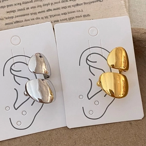 Minimalist pebble-shaped ear cuffs in gold and silver finish with polished mirror texture