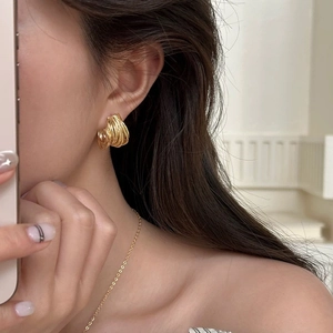 Élégantes boucles d'oreilles dorées en forme de C avec un design multicouche raffiné
