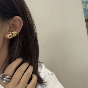 Chic golden ball earrings and textured silver ring set worn by model for a modern look