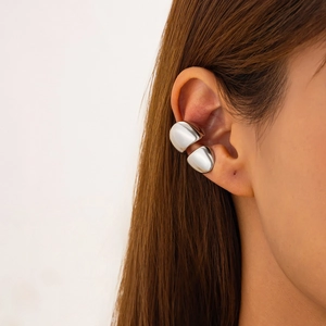 Close-up of polished silver ear cuff with a liquid metal texture on the ear
