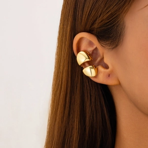 Close-up of sleek gold ear cuffs featuring a polished finish on a female model's ear