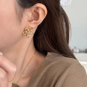 Élégantes boucles d'oreilles fleurs ajourées dorées portées pour un look chic