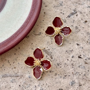Elegant four-petal flower earrings in deep red enamel finish with golden metallic edges