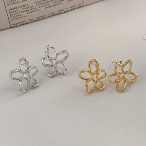 Gros plan détaillé de boucles d'oreilles fleurs ajourées en finitions or et argent