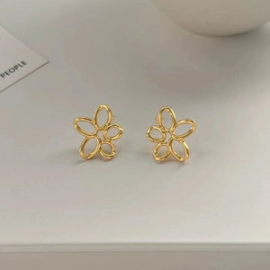 Détails de boucles d'oreilles fleurs ajourées dorées avec une finition métal polie