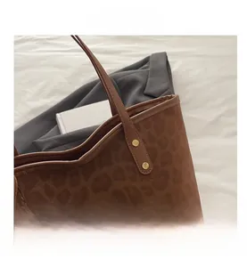 Détail du sac cabas léopard avec texture en daim doux et détails de rivets métalliques