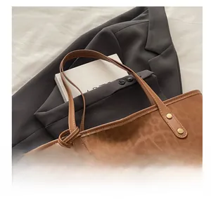 Gros plan du sac fourre-tout léopard avec rivets dorés et pochette assortie incluse
