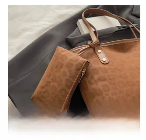 Détail du sac cabas léopard avec mini pochette assortie et bandoulière en cuir