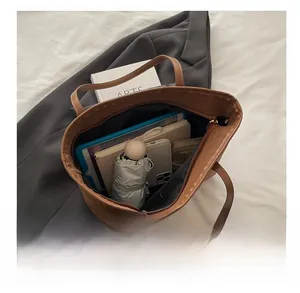 Vue détaillée de la grande capacité du sac cabas léopard avec divers accessoires inclus