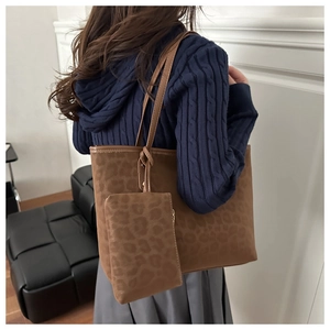 Détail de l'ensemble de sacs léopard comprenant un grand sac fourre-tout et une pochette assortie
