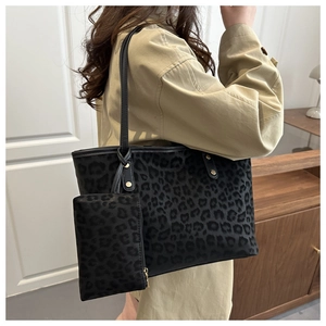Détail du cabas à imprimé léopard avec pochette assortie et boucles dorées élégantes