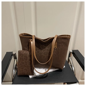 Vue détaillée du grand sac cabas léopard avec sa pochette zippée assortie sur chaise