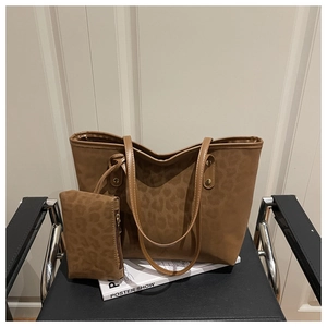 Détail du sac fourre-tout léopard marron café avec pochette sur une chaise vintage