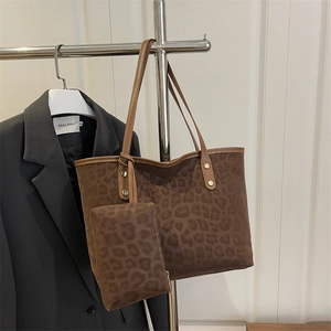 Brown leopard print tote bag with matching pouch on a minimalist metal hanger display