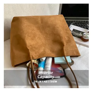 Spacious interior of brown suede tote bag showing storage for laptop and daily essentials