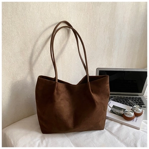 Large dark brown suede tote bag styled with laptop and headphones for a lifestyle view