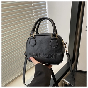 Détail du lettrage COIH'2DN embossé sur la surface du sac à main noir texturé chic