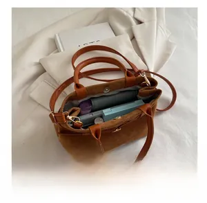 Intérieur spacieux du sac cabas en daim montrant le rangement pour portefeuille et maquillage