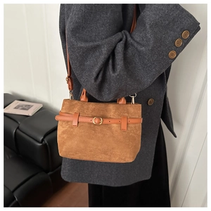 Détail du sac cabas en daim caramel avec ceinture sur mannequin en blazer gris
