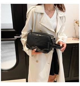 Close-up of black leather clutch bag with dual zippers and side handle for women