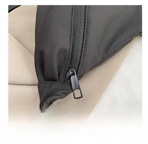 Detail of smooth high-quality metal zipper on black nylon shoulder bag with matte finish