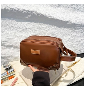 Deep brown faux leather cosmetic bag with triple zipper layers and LOKE patch detail