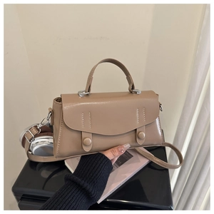 Detail of beige faux leather envelope bag with round decorative buttons and thick handle