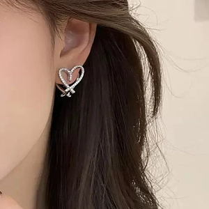 Detailed view of heart-shaped earrings with sparkling cubic zirconia on a model