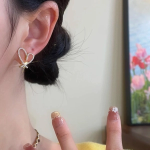 Close-up of elegant gold heart earrings with micro-paved cubic zirconia on model ear