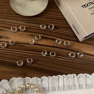 Polished silver-tone layered textured hoop earrings on a vintage aesthetic background