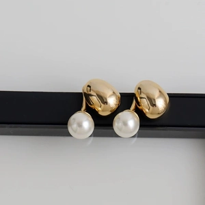 Minimalist gold stud earrings with round white pearls and polished metallic pebble design