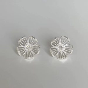 Detail of silver hollow flower stud earrings with sparkling pavé center stones