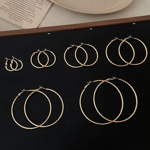 Set of six pairs of graduated gold hoop earrings elegantly arranged on a display board