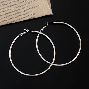 Classic silver geometric hoop earrings with a polished finish on a black background