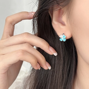 Elegant silver four-leaf flower stud earring with blue petals and a zircon center