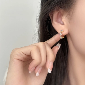 Elegant gold C-shaped flower stud earrings with blue zircon and sparkling crystals