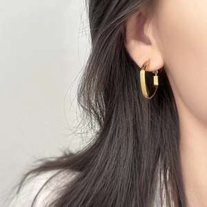 Minimalist square geometric gold earrings with textured finish on female model