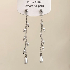 Detailed close-up of elegant long pearl fringe earrings with silver chains and drop pearls