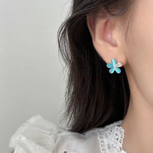 Elegante Blumenstecker mit blauen Opal-Blütenblättern und Zirkon am Ohr des Modells