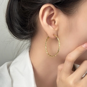 Élégantes boucles d'oreilles créoles torsadées dorées au design géométrique minimaliste