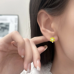 Boucles d'oreilles fleurs vert citron avec zircon étincelant portées par un mannequin