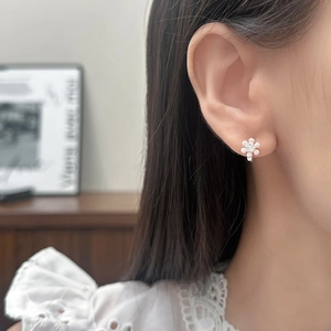 Élégantes petites boucles d'oreilles fleur rose avec zircon portées par un mannequin