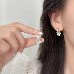 Elegant silver flower earrings with micro-paved zircons shown worn on model