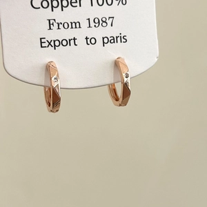Detail of rose gold geometric hoop earrings made of 100% copper with cubic zirconia