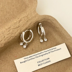 Gros plan sur les boucles d'oreilles doubles en argent avec pendants en zircon