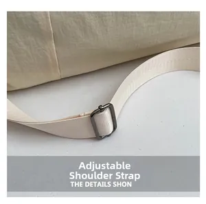 Detail of adjustable nylon strap with gunmetal buckle on minimalist beige travel bag