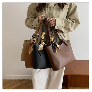 Group of four leather tote bags in neutral tones with decorative scarves for commuting