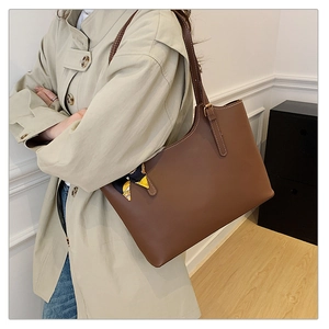 Brown leather tote bag with decorative printed scarf shown on model for daily commuting