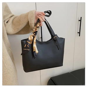Detail of black tote bag with micro-gloss leather and decorative printed silk scarf